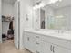 Bright bathroom with double sinks, white cabinets, a large mirror, and walk-in closet access at 876 Samples Nw Ln, Atlanta, GA 30318