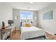 A bright bedroom with hardwood floors, a bed with a yellow pillow, and a desk area by the window at 876 Samples Nw Ln, Atlanta, GA 30318