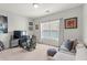 Cozy bedroom featuring neutral walls, plush carpet, and a comfortable seating area by the bright window at 876 Samples Nw Ln, Atlanta, GA 30318