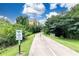 Long driveway with directional markers surrounded by lush trees and blue skies with fluffy clouds above at 876 Samples Nw Ln, Atlanta, GA 30318