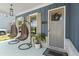 Inviting front porch featuring hanging chairs, stylish lighting, and a welcoming entrance at 876 Samples Nw Ln, Atlanta, GA 30318