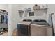 Laundry room with modern washer and dryer and storage shelving at 876 Samples Nw Ln, Atlanta, GA 30318