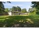 Spacious backyard with lush green grass surrounded by mature trees and a wooden fence, providing privacy at 159 Lloyd Dr, Marietta, GA 30066