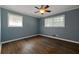 Blue bedroom with ceiling fan, crown molding, hardwood floors and two large windows at 159 Lloyd Dr, Marietta, GA 30066