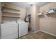 Functional laundry room featuring white appliances and ample shelving for organized storage solutions at 159 Lloyd Dr, Marietta, GA 30066