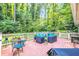 Relaxing deck area featuring stylish outdoor furniture, mature trees, and a privacy fence at 1445 Woodhill Dr, Marietta, GA 30066
