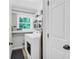 Bright laundry room with washer, dryer, shelving, and a view to the trees outside at 1445 Woodhill Dr, Marietta, GA 30066