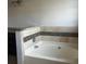 A luxurious soaking tub is tiled with contrasting decorative accents at 1910 Glynmoore Dr, Lawrenceville, GA 30043