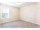 This bedroom features neutral walls, carpet, and a large window offering natural light at 4628 Mcever View Dr, Sugar Hill, GA 30518