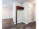 Hallway with dark wood-look floors, neutral walls and trim, and a storage nook with overhead cabinet at 4628 Mcever View Dr, Sugar Hill, GA 30518