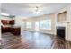 Open-concept living room with hardwood flooring, fireplace, and seamless connection to the kitchen at 4628 Mcever View Dr, Sugar Hill, GA 30518