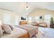 Spacious main bedroom with high ceilings, ceiling fan, ample windows, and light-colored walls and carpet at 4628 Mcever View Dr, Sugar Hill, GA 30518