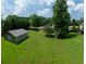 Expansive backyard featuring lush green grass, mature trees, and a detached shed for extra storage at 2081 Old Peachtree Road Northeast Rd, Lawrenceville, GA 30043