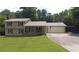 Charming two-story house with a metal roof, a wide garage, a carport, and a well-maintained lawn at 2081 Old Peachtree Road Northeast Rd, Lawrenceville, GA 30043