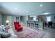Open-concept living room featuring a bar area and a stylish red armchair with plush, neutral furnishings at 2081 Old Peachtree Road Northeast Rd, Lawrenceville, GA 30043
