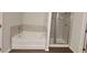 Bright bathroom with a separate tub and glass-enclosed shower at 210 Park Place Trl, Social Circle, GA 30025
