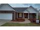 Charming brick home featuring a two-car garage and inviting front porch at 210 Park Place Trl, Social Circle, GA 30025