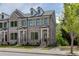Charming brick townhome featuring a welcoming front porch and manicured landscaping at 130 W Main Street # 1, Buford, GA 30518
