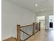 Hallway with wood floors, wooden railing and leading to a laundry room with white cabinets at 130 W Main Street # 1, Buford, GA 30518