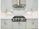 Kitchen with stainless steel range hood and gas cooktop with white cabinets at 130 W Main Street # 1, Buford, GA 30518