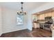 Cozy dining area with stylish chandelier and hardwood flooring, open to the adjacent kitchen at 512 Allendale Dr, Decatur, GA 30032