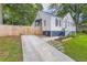 A driveway leads to a cute brick home with blue shutters and a cozy front porch, surrounded by a well-kept lawn at 512 Allendale Dr, Decatur, GA 30032
