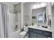 Bathroom with tub and shower, modern vanity with sink, decorative mirror, and neutral color scheme for a soothing ambiance at 5473 Heatherbrooke Nw Dr, Acworth, GA 30101