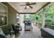 A covered deck with ceiling fan, outdoor seating, and lush greenery provides a relaxing outdoor space at 5473 Heatherbrooke Nw Dr, Acworth, GA 30101