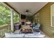 Covered patio featuring a ceiling fan, TV, seating area, and stone fireplace, perfect for relaxation and outdoor entertainment at 5473 Heatherbrooke Nw Dr, Acworth, GA 30101