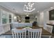 Dining area with a wood table and white chairs, transitioning into a living room with built-in shelves and a fireplace at 5473 Heatherbrooke Nw Dr, Acworth, GA 30101