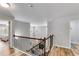 Hallway with wooden railing, neutral walls, leading to the bedrooms with views of a sunny window at 5473 Heatherbrooke Nw Dr, Acworth, GA 30101
