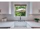 Bright kitchen sink with a white countertop and white subway tile backsplash under a window with a view to the outside at 5473 Heatherbrooke Nw Dr, Acworth, GA 30101