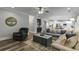 Open-concept living room features hardwood floors, a comfortable sectional sofa, and seamless flow into the dining and kitchen areas at 5473 Heatherbrooke Nw Dr, Acworth, GA 30101