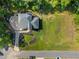 An aerial view of a residence showcasing well-maintained landscaping, a gray roof, and a spacious green lawn at 6070 Lively Ct, Cumming, GA 30040