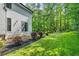 Well-maintained backyard featuring lush green grass and manicured landscaping against a wooded backdrop at 6070 Lively Ct, Cumming, GA 30040