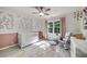 Bright Bedroom with a white crib, floral wallpaper accents and large windows at 6070 Lively Ct, Cumming, GA 30040