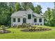 Charming home featuring professionally landscaped lawn with rock terracing, lush shrubs, and black frame windows at 6070 Lively Ct, Cumming, GA 30040