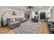 Spacious living room featuring hardwood floors, gray sectional sofa, and double door entry at 6070 Lively Ct, Cumming, GA 30040