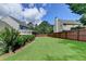 Spacious back yard features lush lawn, screen porch, a wood fence, and beautiful landscaping, perfect for outdoor activities and privacy at 939 Flowers Xing, Lawrenceville, GA 30044
