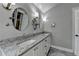 Bright bathroom featuring a granite countertop, double sinks and decoratively lit round mirrors at 939 Flowers Xing, Lawrenceville, GA 30044