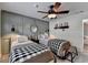 Cozy bedroom featuring two twin beds, decorative wall paneling, and stylish ceiling fan at 939 Flowers Xing, Lawrenceville, GA 30044