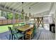 Stylish screened-in porch with a long dining table, decorative chandelier, and lovely backyard views at 939 Flowers Xing, Lawrenceville, GA 30044