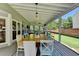 An enclosed sunroom features a large dining table with lots of natural light from large windows at 939 Flowers Xing, Lawrenceville, GA 30044