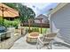 A stylish outdoor patio includes a built in grill and stone fire pit with an outdoor swing and seating at 939 Flowers Xing, Lawrenceville, GA 30044
