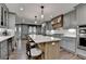 Stylish kitchen boasts gray cabinetry, a large island with seating, and stainless steel appliances at 939 Flowers Xing, Lawrenceville, GA 30044