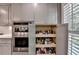 Kitchen features stainless steel appliances, double ovens, white cabinets, and organized pull out pantry shelving at 939 Flowers Xing, Lawrenceville, GA 30044