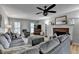 Inviting living room with brick fireplace, neutral color palette, ceiling fan, and comfortable gray sectional couch at 939 Flowers Xing, Lawrenceville, GA 30044