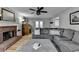 Spacious living room with brick fireplace, a large sectional, an ottoman, and a decorative rug on hardwood floors at 939 Flowers Xing, Lawrenceville, GA 30044