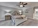 Main bedroom with neutral decor, ceiling fan, furnishings, dresser, and a view of the en suite bath at 939 Flowers Xing, Lawrenceville, GA 30044