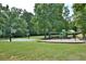 Community playground with swings, basketball court and lush green space, perfect for outdoor activities and Gathering fun at 939 Flowers Xing, Lawrenceville, GA 30044